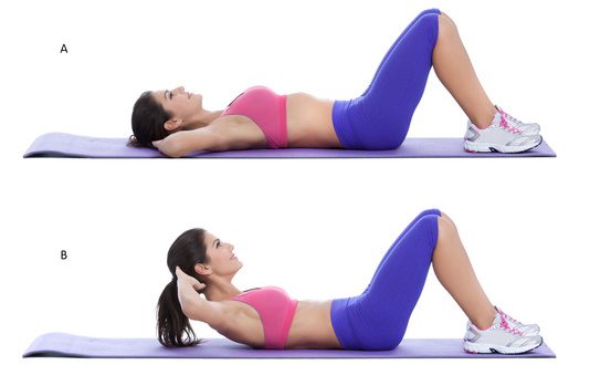 Woman doing crunches on a yoga mat with a smile on her face.